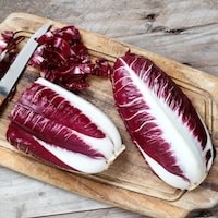 Red and white chicory on chopping board